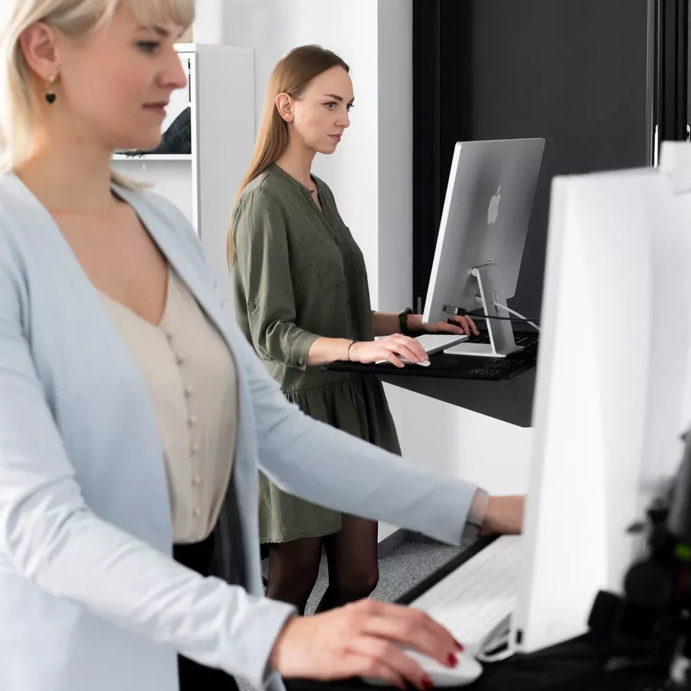 Zwei Frauen arbeiten an Computern in einem Orbitvu-Fotostudio