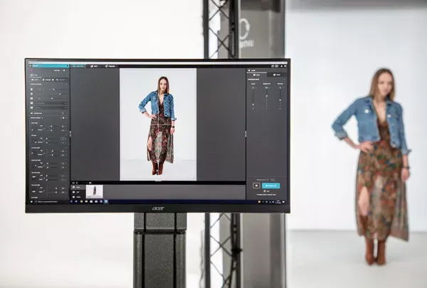 Prüfung eines E-Commerce-Mode-Fotoshootings auf dem Monitor mit Model im Maxikleid