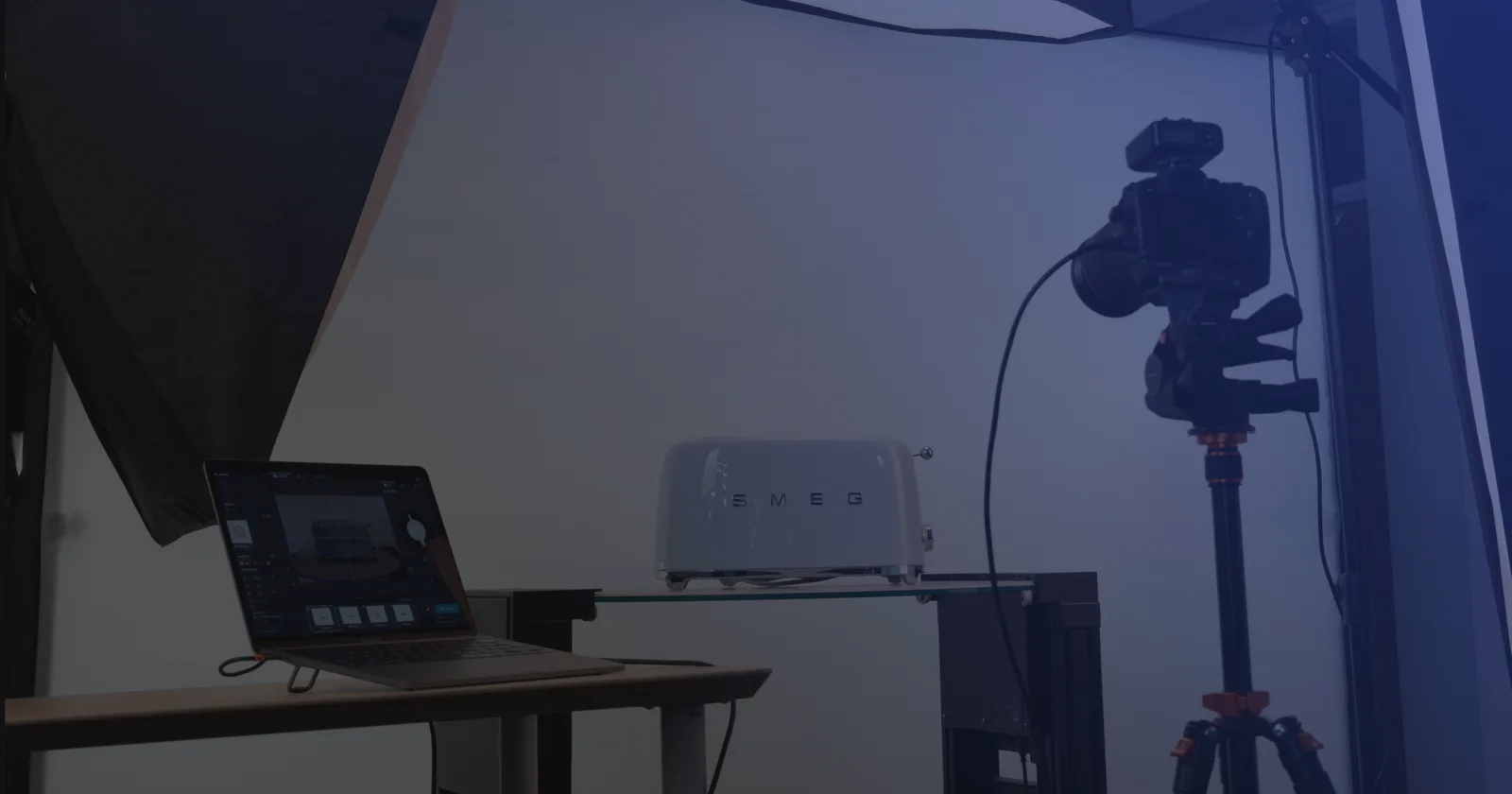 Tethering-Setup in der Produktfotografie - ein Laptop mit Aufnahmesoftware neben einer Kamera auf dem Stativ und einem Produkt auf einer Glasplatte