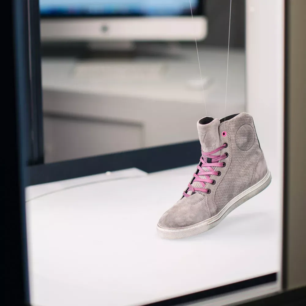 Produktfoto eines grauen High-Top-Sneakers aus Wildleder mit pinken Schnürsenkeln