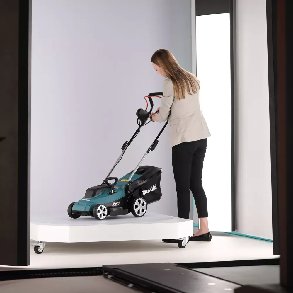 Frau bedient einen kabellosen Makita-Rasenmäher im Studio