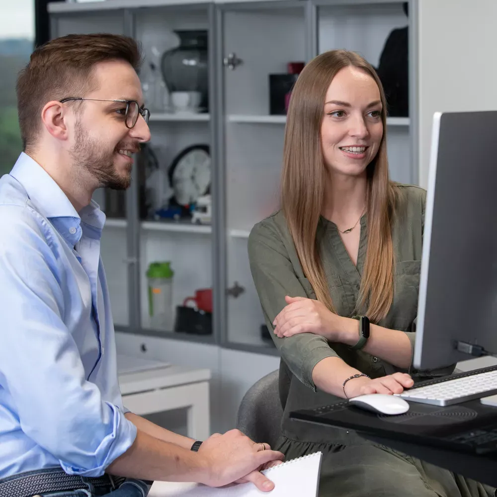 Zwei Kollegen arbeiten gemeinsam am Computer