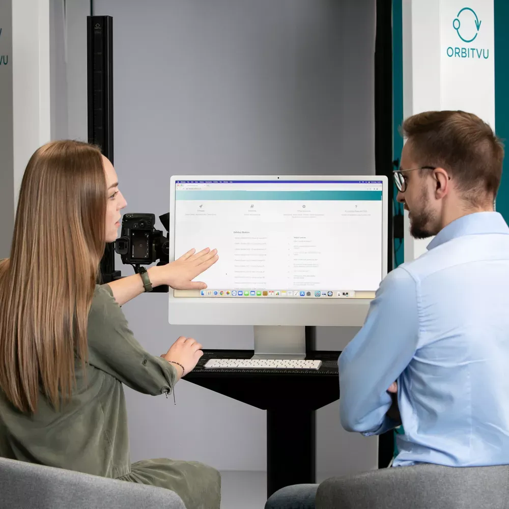 Zwei Kollegen prüfen Software auf einem Computermonitor