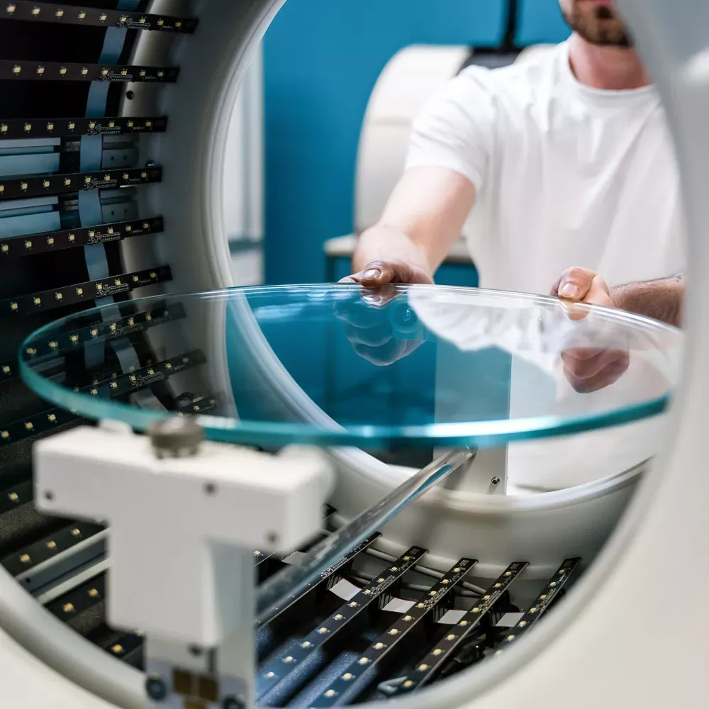 Techniker platziert einen Glasdrehteller in einem automatisierten Fotostudio